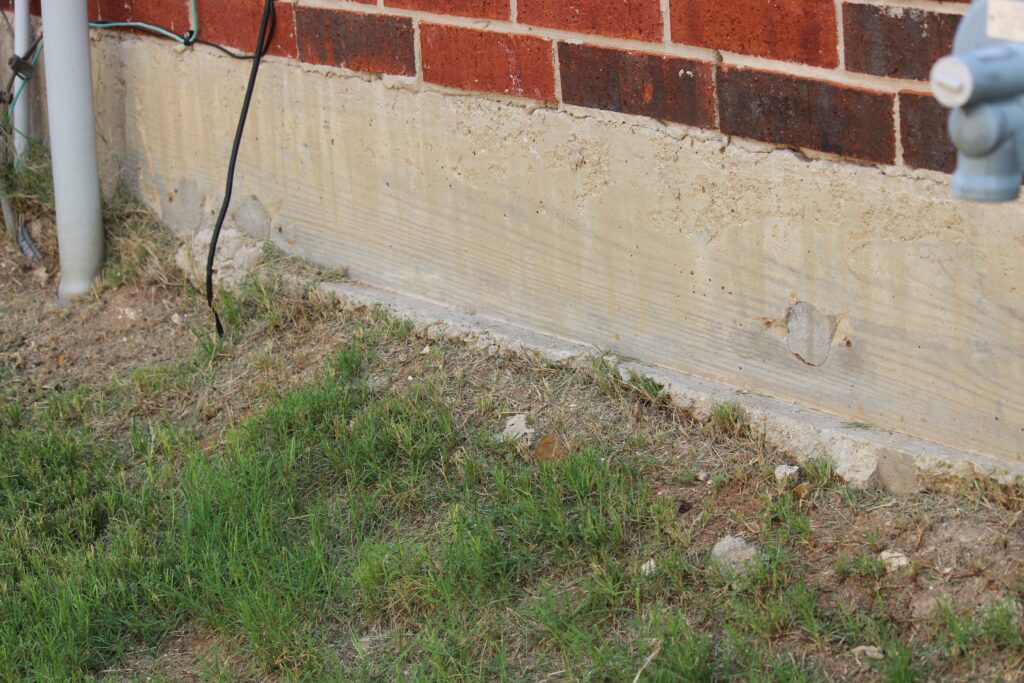 Foundation exposed below the bottom of the brick line