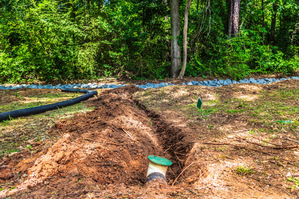 French drain with pop up valve in ground with trench dug for an extension